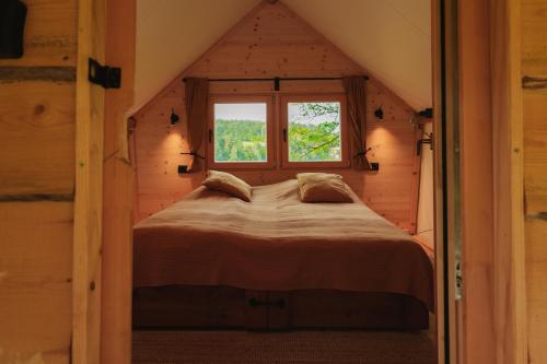 a bedroom in a log cabin with a large bed at Lakeside Glamping Tents Mažijev Grič in Gradišče pri Lukovici
