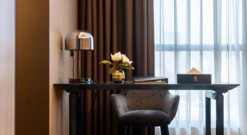 a desk in a hotel room with a vase of flowers at Taiyi International Hotel in Wenzhou
