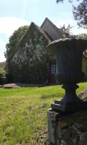 a statue in front of a house in a yard at Gîte De Serre in Le Grand-Pressigny