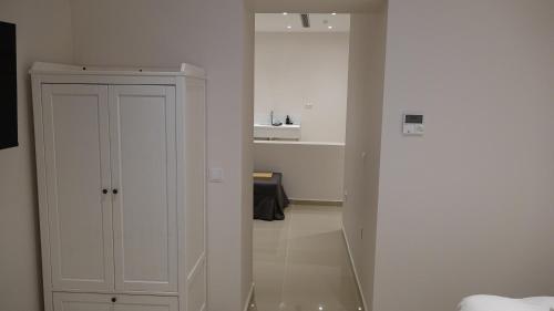 a white room with a white cabinet and a hallway at Epirus Easy Stay in Ioannina