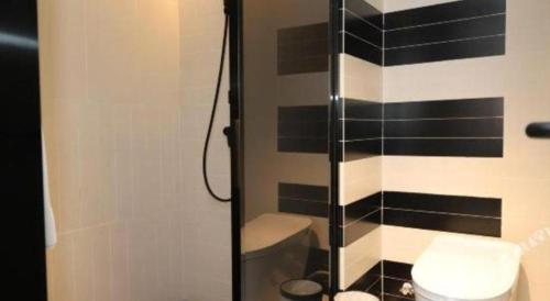a bathroom with a toilet and a glass shower at ibis Dongguan Dongcheng in Dongguan