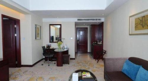 a living room with a couch and a desk at Gaosu New Century Hotel International Anhui in Hefei