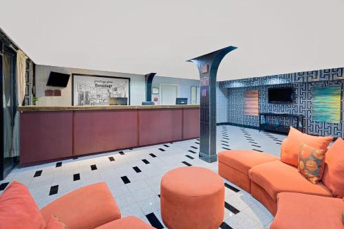 a waiting room with orange furniture in a building at Super 8 by Wyndham Hermitage Nashville in Hermitage