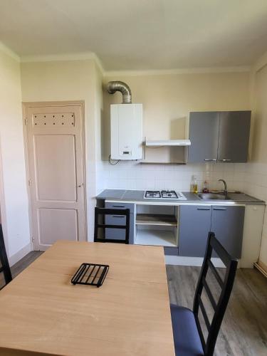 - une cuisine avec une table, une cuisinière et un évier dans l'établissement Cozy Zen de Paray 2 bedroom, à Paray-le-Monial