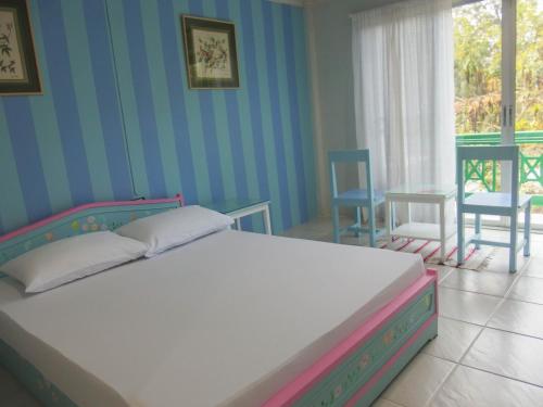 a bedroom with a bed and a table and chairs at Makmai Villa - Rayong in Ban Phe