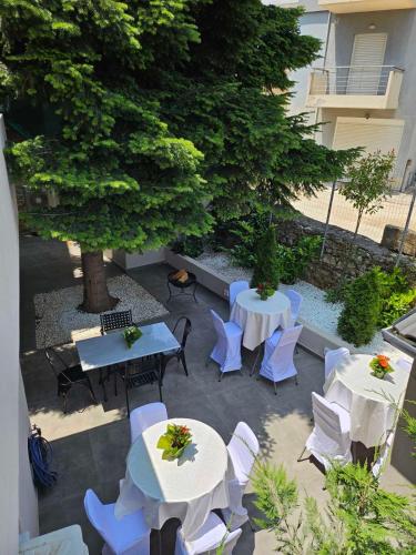a patio with tables and chairs and a tree at Epirus Easy Stay in Ioannina