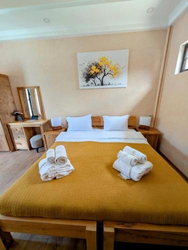 a bedroom with a bed with towels on it at Hotel Leoni in Kʼveda Sakʼara