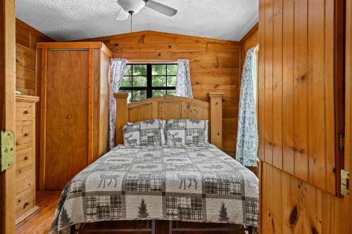 a bedroom with a bed and a window at Cozy Cabin, Fireplace, WiFi, Hot Tub, Views! in Sevierville