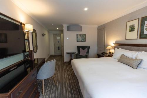 a hotel room with a bed and a flat screen tv at DoubleTree by Hilton Cheltenham-Cotswolds in Cheltenham