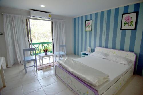 a bedroom with a bed and a table and chairs at Makmai Villa - Rayong in Ban Phe