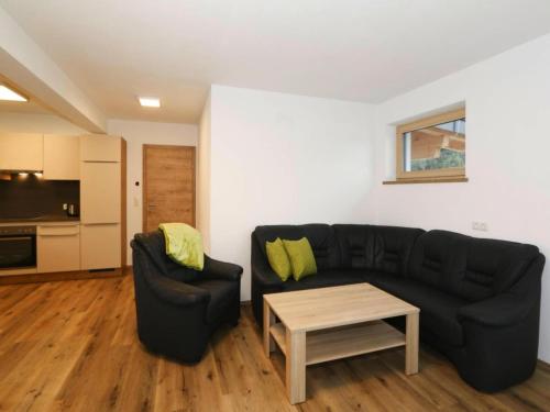 a living room with a black couch and a table at Apartment in Aschau at the lake in Aschau