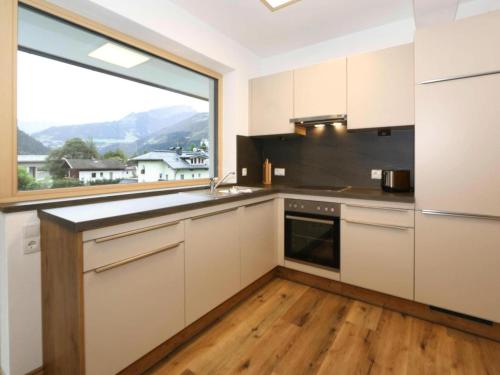 a kitchen with white cabinets and a large window at Apartment in Aschau at the lake in Aschau
