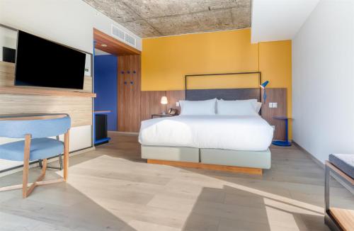 a bedroom with a bed and a flat screen tv at Tru By Hilton Chillan Ferrat in Chillán