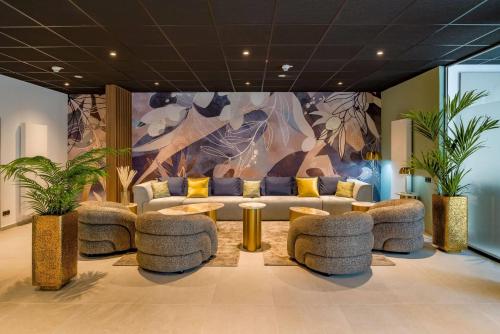 a lobby with couches and a table and plants at Aspire Palais Recklinghausen, Trademark Collection by Wyndham in Recklinghausen