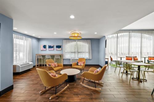 a waiting room with chairs and tables and windows at Spark by Hilton Spring Lake Fayetteville in Spring Lake