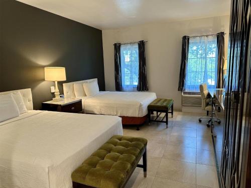 a hotel room with two beds and a chair at Rocklin Park Hotel, Trademark Collection by Wyndham in Rocklin