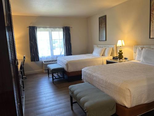 a hotel room with two beds and a window at Rocklin Park Hotel, Trademark Collection by Wyndham in Rocklin