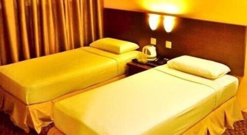 a hotel room with two beds and a telephone at YMCA Kuala Lumpur in Kuala Lumpur