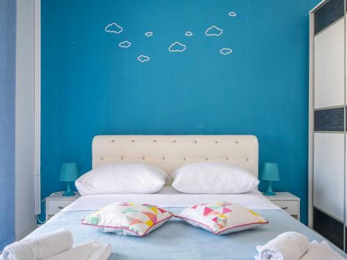 a blue bedroom with a bed with two pillows at LaidBack Apartments - Standard One Bedroom Apartment with Balcony and Sea View Azur in Orebić