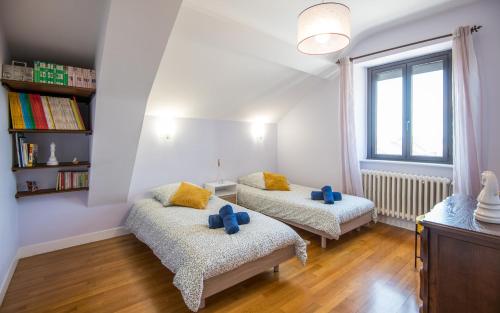 a living room with two beds and a window at L'Agentole - Au coeur des palanges, proche Rodez in Agen dʼAveyron