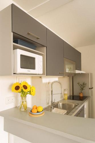 a kitchen with a sink and a microwave at Studio Les Salines Orient-Bay in Orient Bay