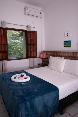 a bedroom with a bed with a towel on it at Pousada do Mineiro in Trancoso