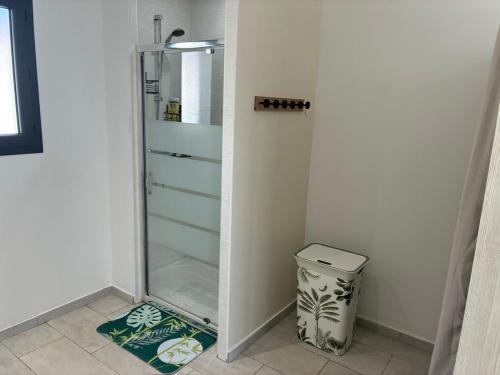 un réfrigérateur en verre dans une pièce avec une poubelle dans l'établissement villa de vacances, à Cessenon