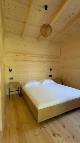 a bedroom with a large bed in a wooden room at Dumbo Eco Camp in Ozurgetʼi