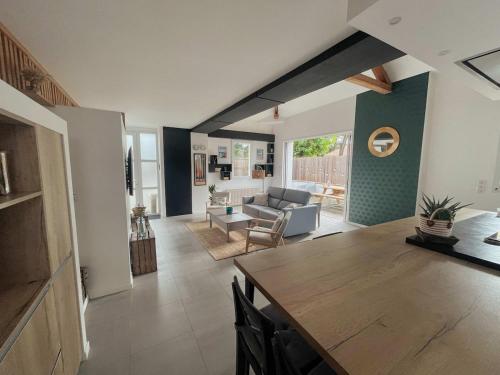 un salon avec une table et un canapé dans l'établissement Villa Cinta, des vacances en bord d'océan, à Capbreton