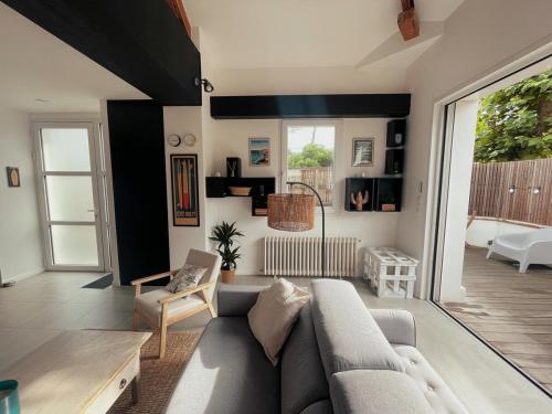 un salon avec un canapé et une table dans l'établissement Villa Cinta, des vacances en bord d'océan, à Capbreton