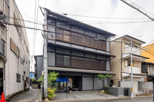 an apartment building with a balcony on a street at MADOKA Kyoto station west in Kyoto