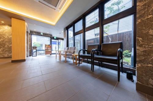a waiting room with leather chairs and large windows at MADOKA Kyoto station west in Kyoto