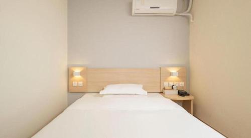 a white bed in a room with two lamps at 7 Days Inn Suzhou Mudu Ancient Town Kaima Auto Market in Suzhou