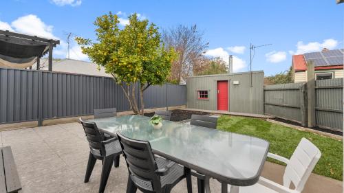 a table and chairs in a backyard with a fence at MacArthur House in Ballarat