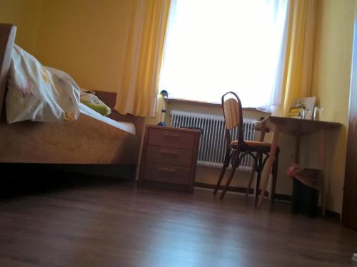 a bedroom with a bed and a desk and a chair at Landhotel SONNENHOF MotorradKrauk in Ulrichsberg