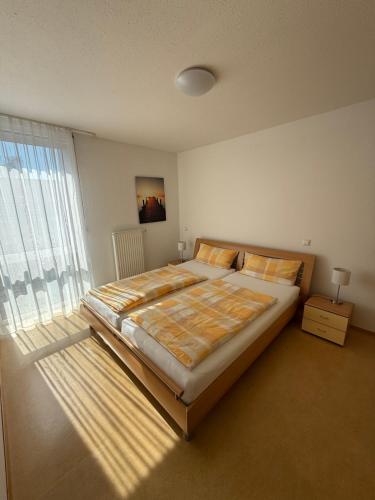 a bedroom with a bed and a large window at Ferienwohnungen Günther Hund in Immenstaad am Bodensee