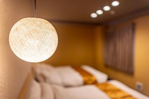 a chandelier hanging over a bed in a room at MADOKA Kyoto station west in Kyoto