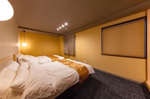 a bedroom with a large bed and a window at MADOKA Kyoto station west in Kyoto