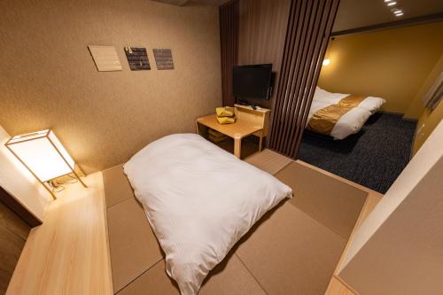 a small room with a bed and a mirror at MADOKA Kyoto station west in Kyoto