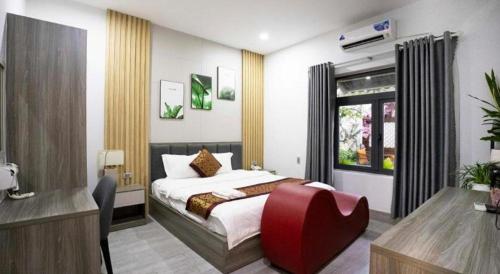ein Schlafzimmer mit einem Bett mit einem roten Stuhl. in der Unterkunft Hoang Mai Hotel in Tây Ninh