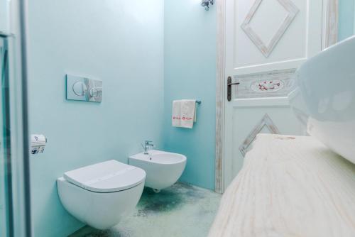 a white bathroom with a toilet and a sink at VILLA AMIRA Porto Cervo con vista Mozzafiato sul Mare,Piscina Privata,WELLNESS & SPA in Liscia di Vacca