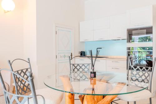 a glass table in a kitchen with two chairs at VILLA AMIRA Porto Cervo con vista Mozzafiato sul Mare,Piscina Privata,WELLNESS & SPA in Liscia di Vacca