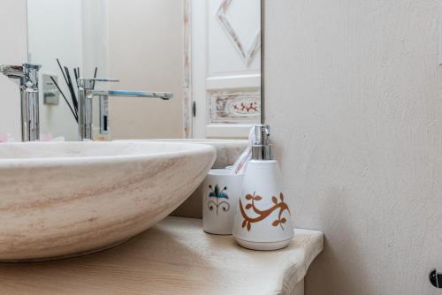 a bathroom with a sink and a counter with two cups at VILLA AMIRA Porto Cervo con vista Mozzafiato sul Mare,Piscina Privata,WELLNESS & SPA in Liscia di Vacca