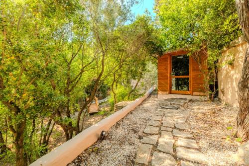 a log cabin in the woods with a walkway at VILLA AMIRA Porto Cervo con vista Mozzafiato sul Mare,Piscina Privata,WELLNESS & SPA in Liscia di Vacca