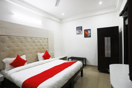 a bedroom with a large bed with red pillows at Collection O Tipsyy Inn in Gurgaon