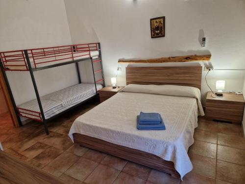 a bedroom with two bunk beds and a blue towel on a bed at La Macciona in Aglientu