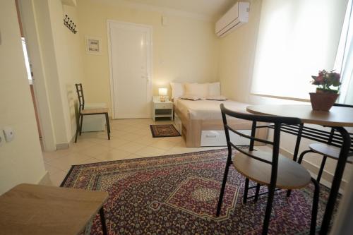 a small room with a bed and a table and chairs at Διαμερίσματα Μαριάννα in Drama