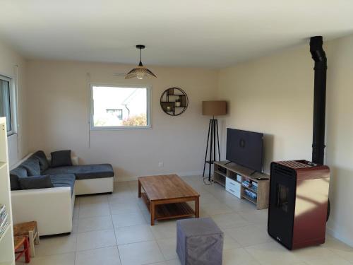 un salon avec un canapé et une télévision dans l'établissement Maison de vacances, à Trégastel