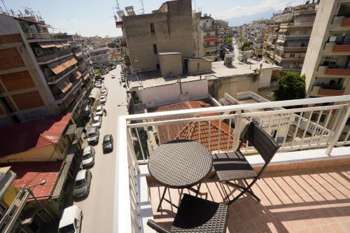 a table and chairs on the balcony of a building at Διαμερίσματα Μαριάννα in Drama