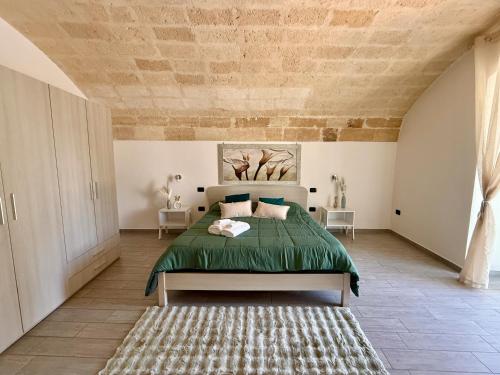 a bedroom with a bed with a green bedspread at Aquamirae - Historic home with panoramic balcony - Affitti Brevi Italia in Gravina in Puglia